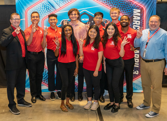 Sport administration students and faculty pose in front of NCAA backdrop.