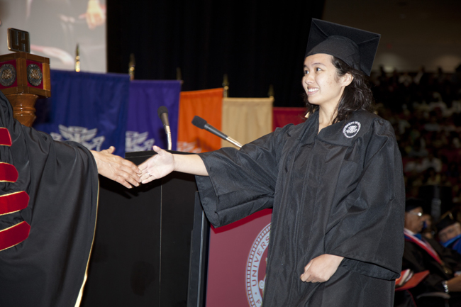 Graduating Student shaking hands symbolinzing the end of a journey