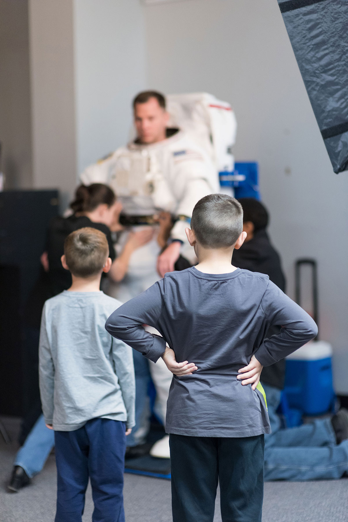 Kids looking at Astronaut Hague getting suit up