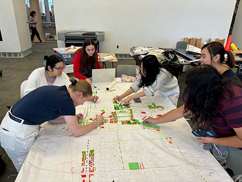 A group of students work on city planning map.