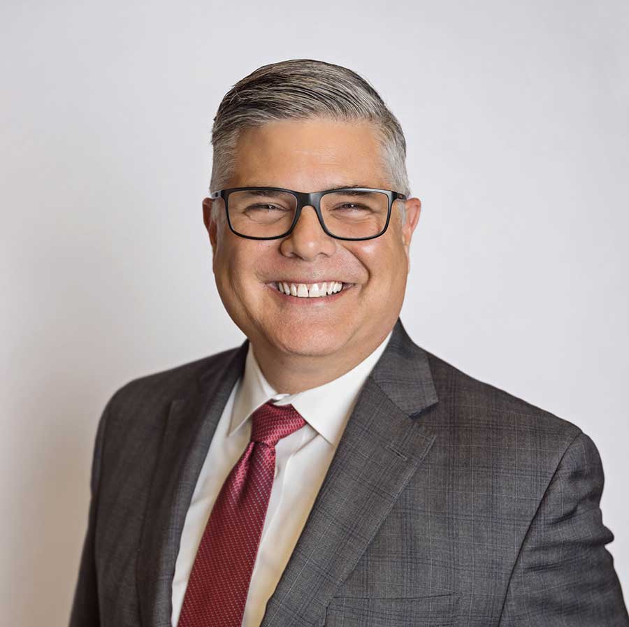 Portrait of Dr. Jay Neal smiling wearing a suit