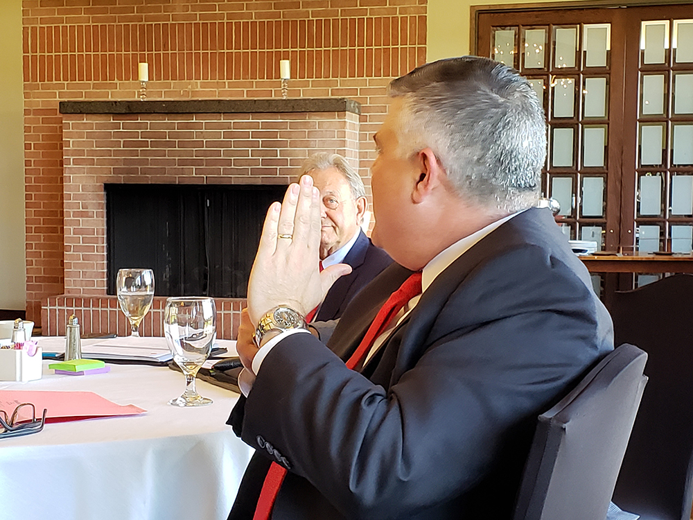 Two men in suits talking at a dining table