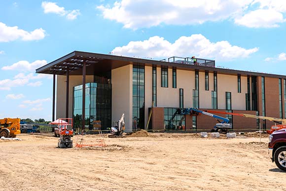 An almost completed building surrounded by equipment