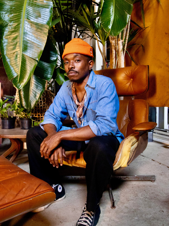 Preston Gaines, artist, sitting on a chair.