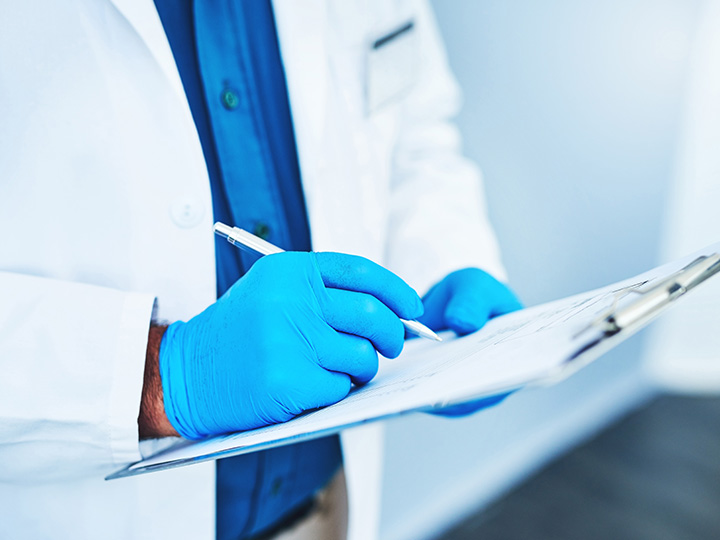 lab scientist doing checks with clipboard
