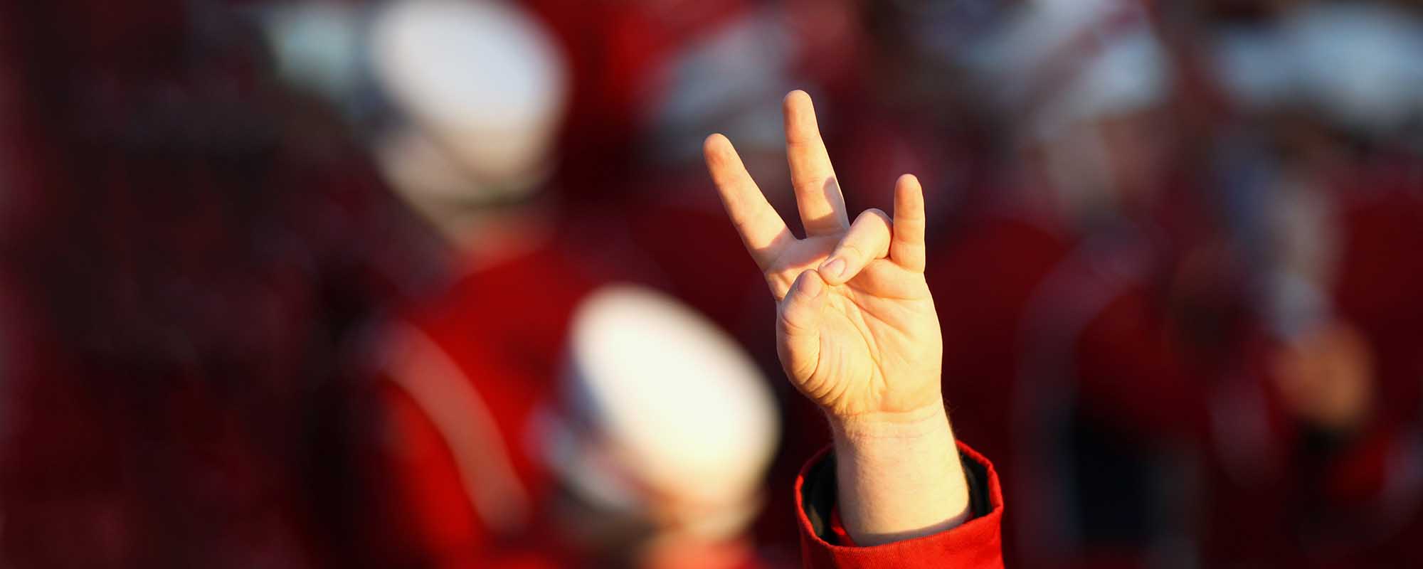 A hand gesturing the UH cougar paw with the ring finger touching the thumb