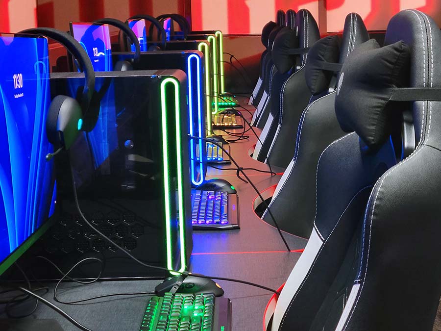 Close up of a row of gaming computers with neon lighting.