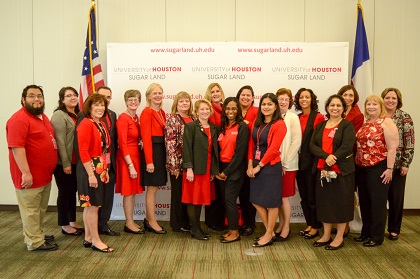 Group of women and men standing in front of backdrop