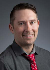 Portrait of a man with short hair smiling