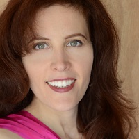 A portrait of a smiling woman with brown hair.