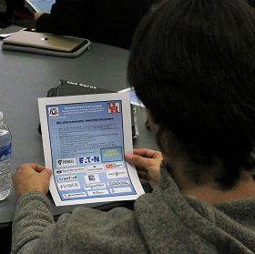 A student holds a club flyer to read