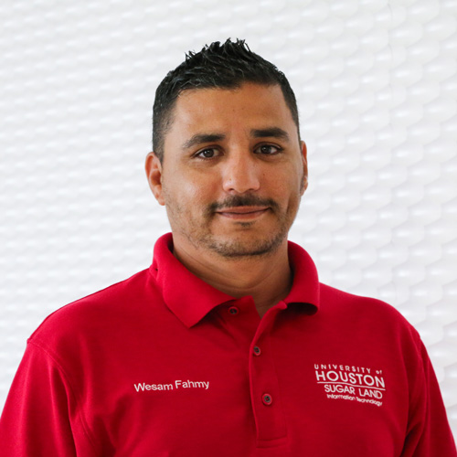 Portrait of an North African man smiling with a Balbo beard wearing a red polo shirt